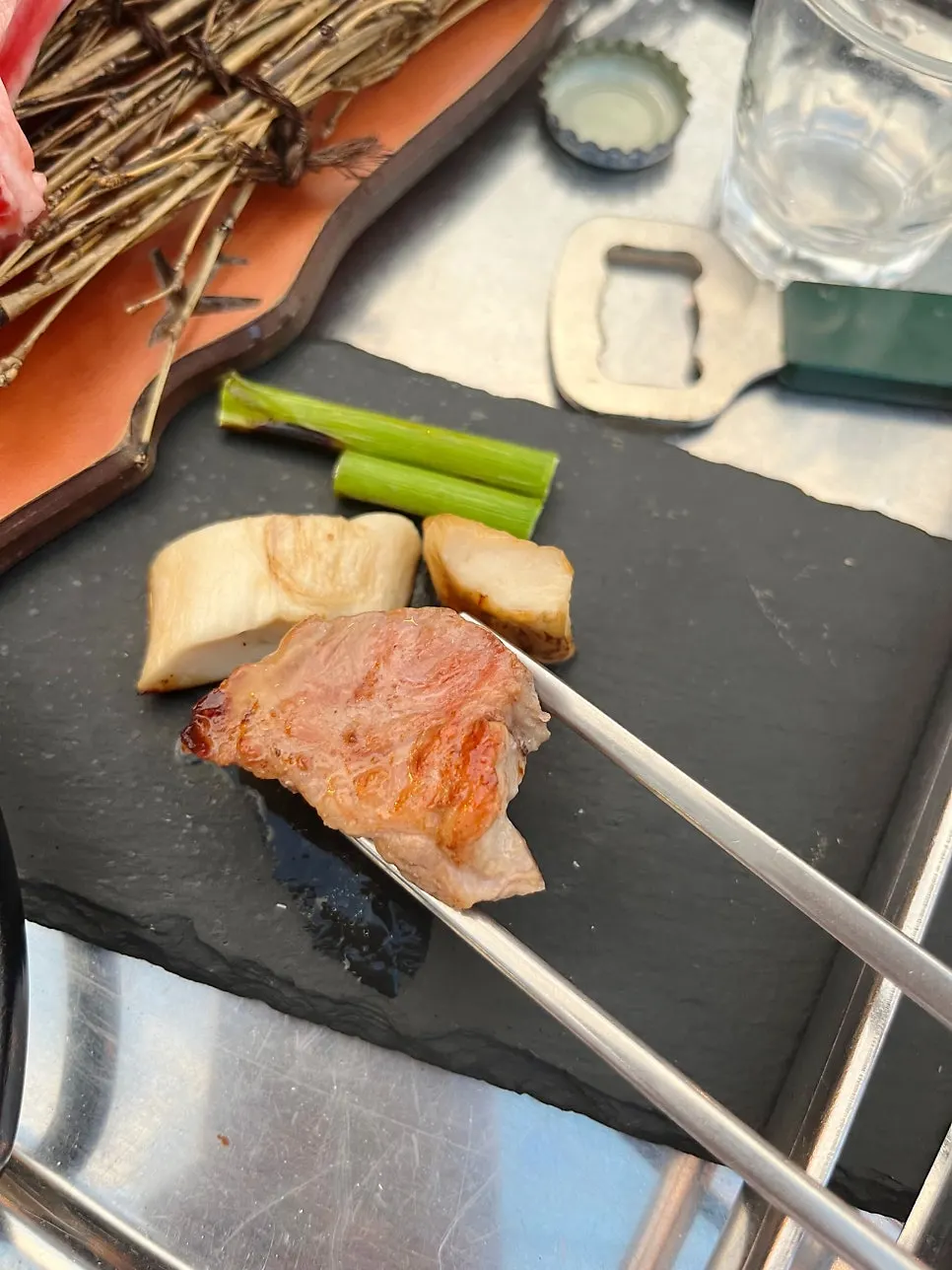 Glasses of drinks set beside the grilling meat