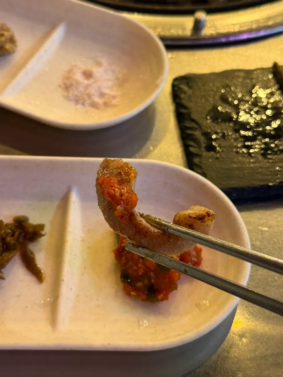 무김치와 오징어젓갈을 곁들인 고기 한 점