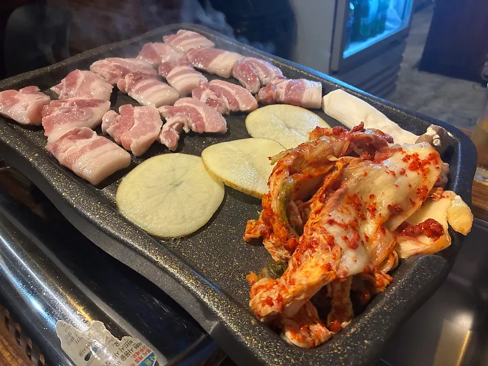 Kimchi and pork belly table setting at Ijjok Kimchi Samgyeopsal near Hapjeong Station