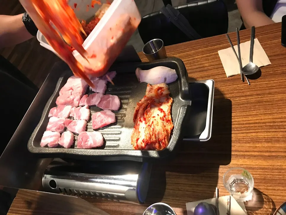 Fresh pork belly cooking on a grill plate
