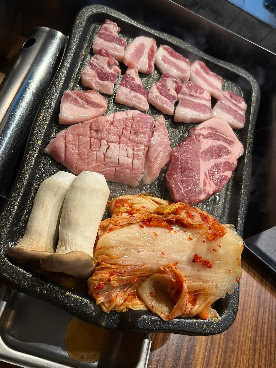 불판 가득 올라간 삼겹살과 김치