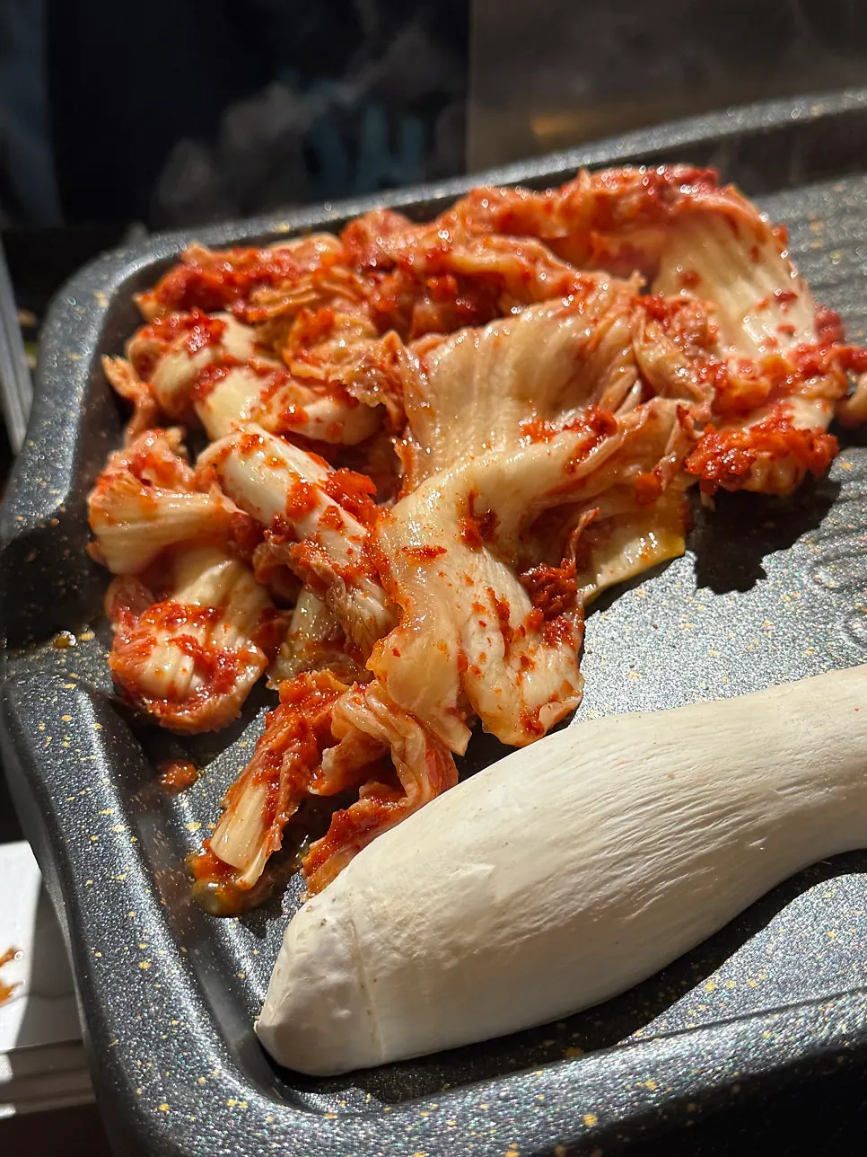 Raw pork neck and whole pork jowl arranged neatly on the grill