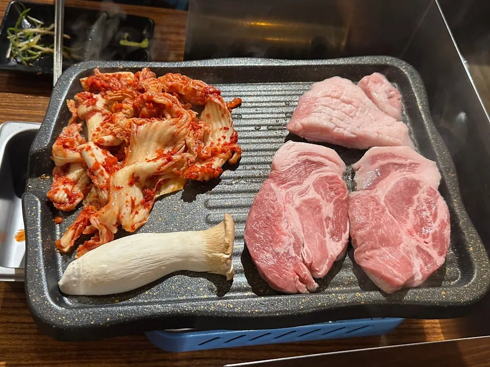 Sour kimchi laid underneath the meat as it grills