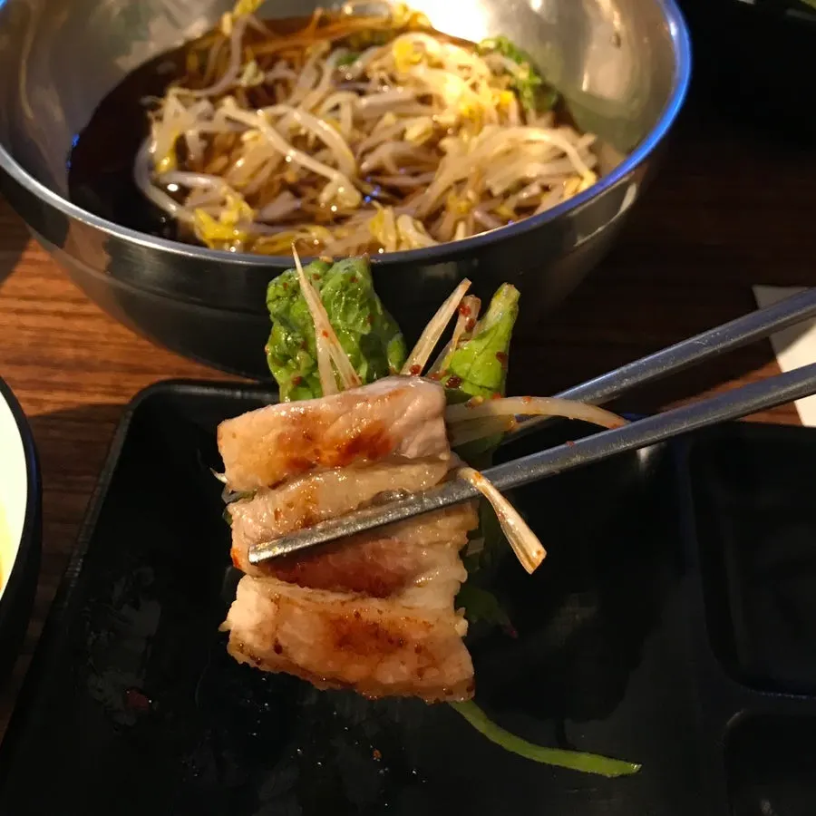 구운 삼겹살에 구운 김치를 올린 모습