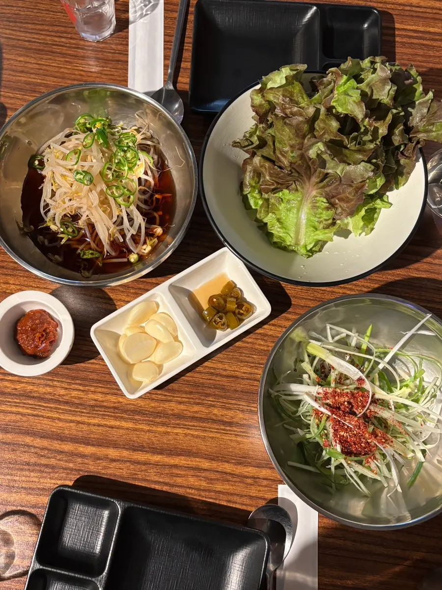 Table setting with lettuce wraps, scallion salad, and bean sprout pickle