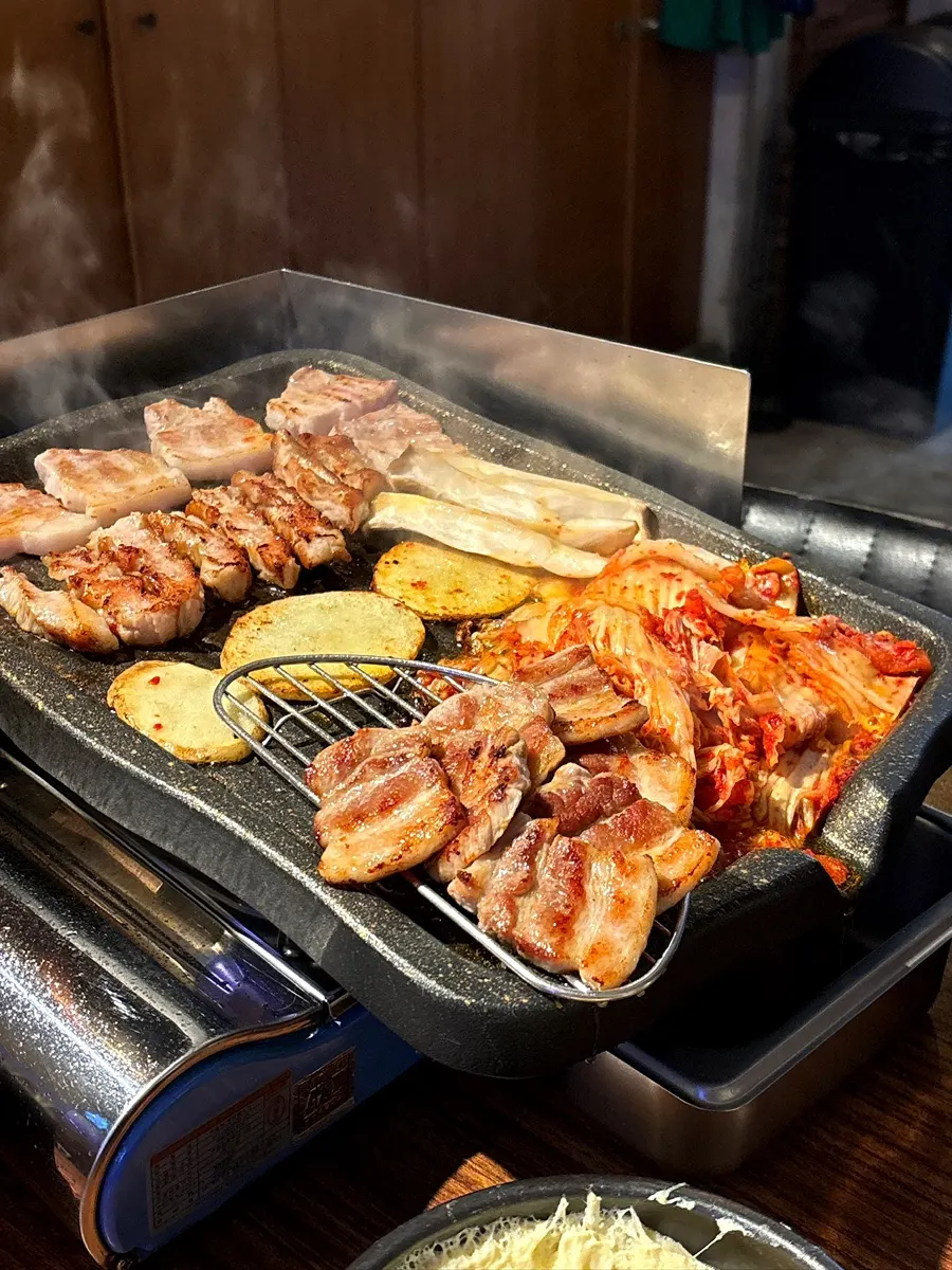 Potatoes and mushrooms cooking on the edge of the grill
