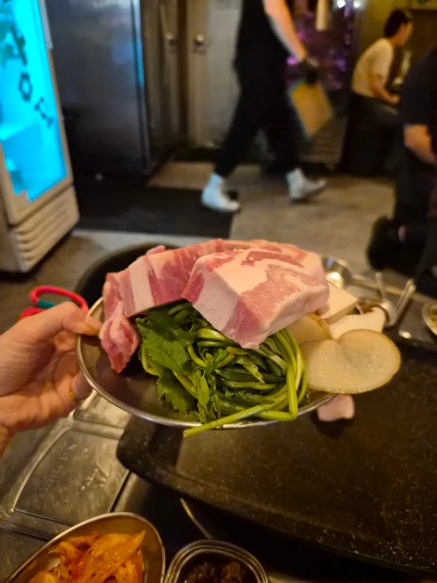 고기 접시 뒤쪽에 놓인 미나리