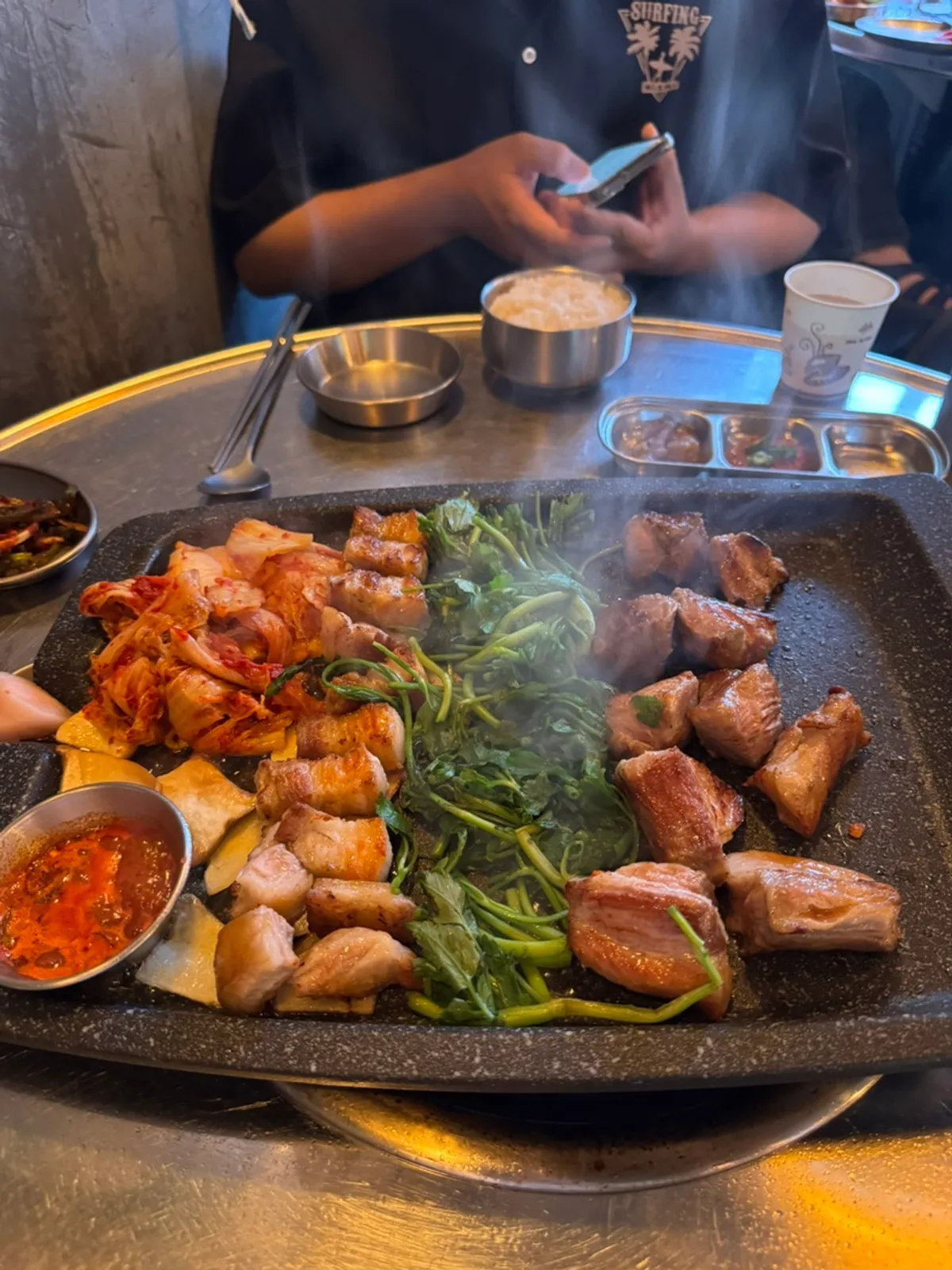 Staff grilling aged pork and side vegetables on the grill