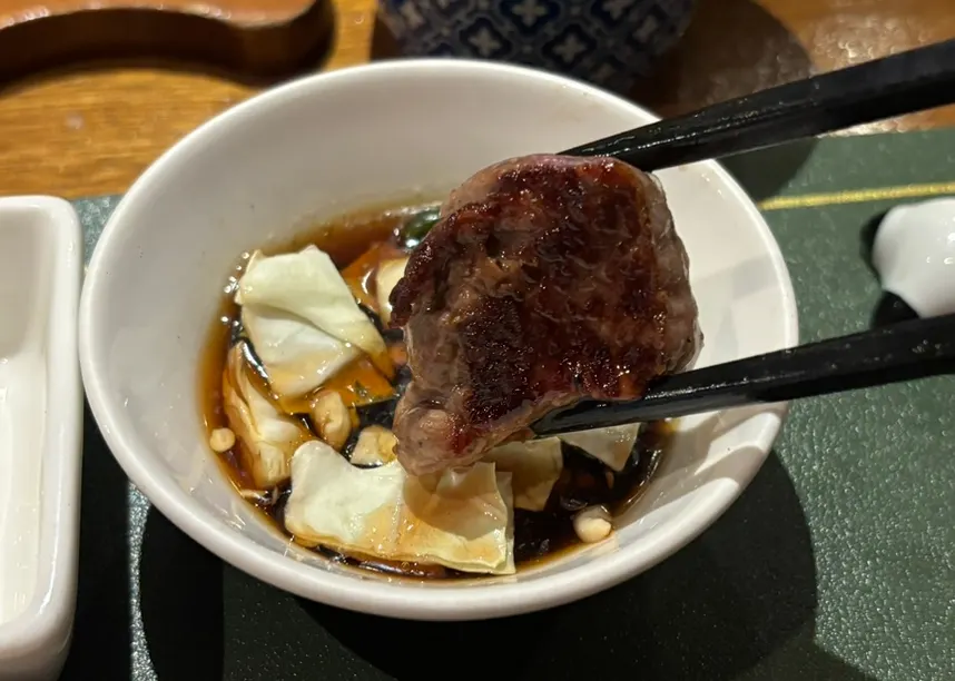 A piece of lamb sirloin dipped in soy sauce