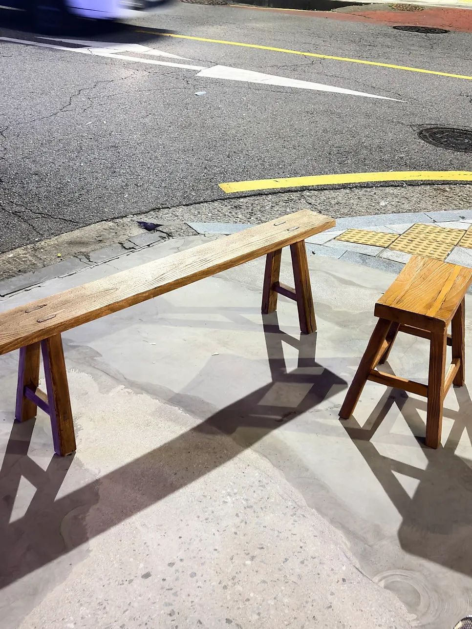 Wooden bench and stools placed outside the café