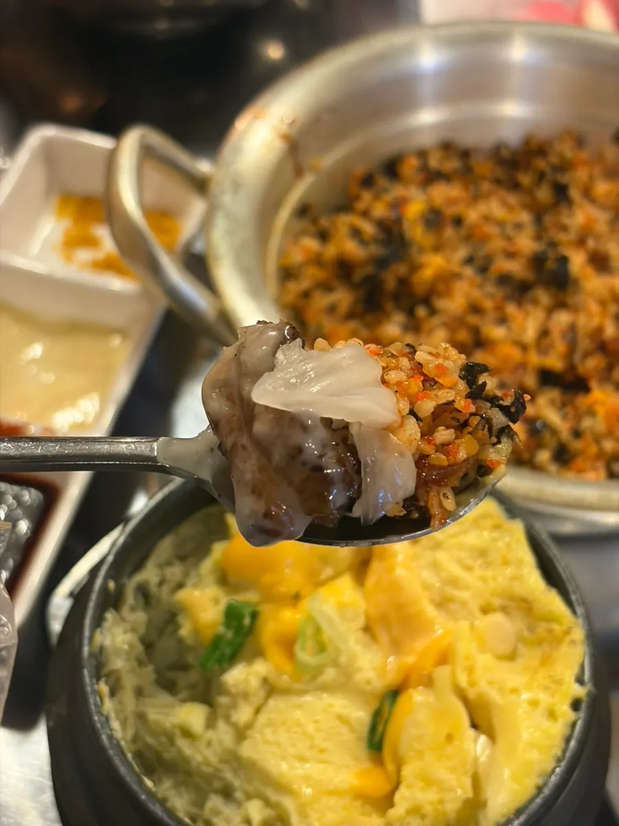 A bite of jjokgalbi with rice ball and baek-kimchi