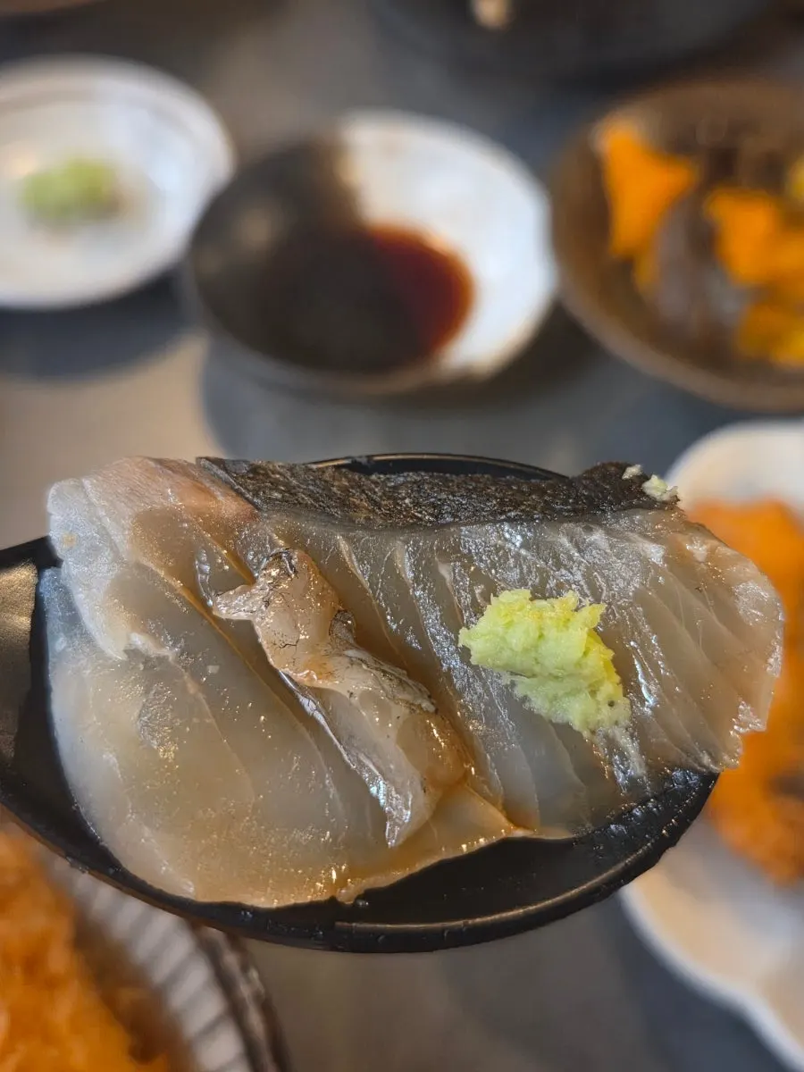 광어와 고등어회를 올린 수저 한 입