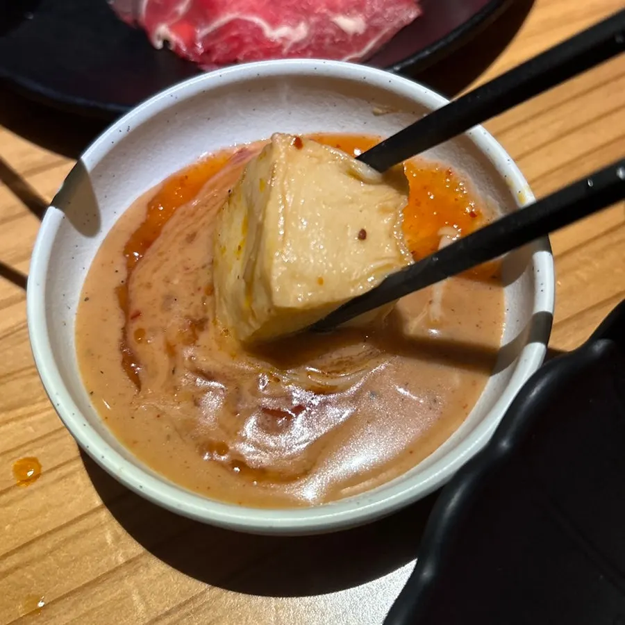 Vegetables and meat cooking in the mala broth shabu-shabu pot