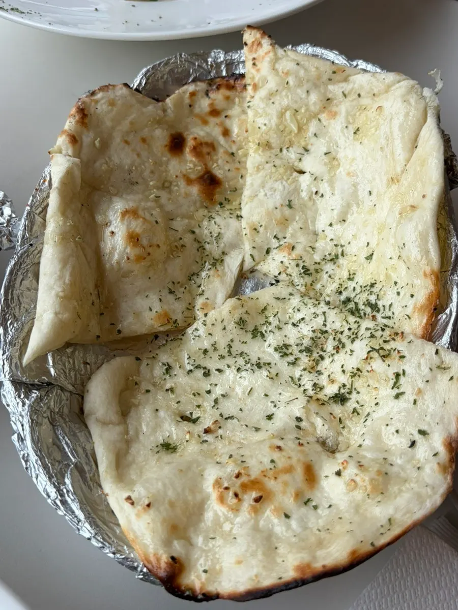 Two plates of butter naan and butter garlic naan