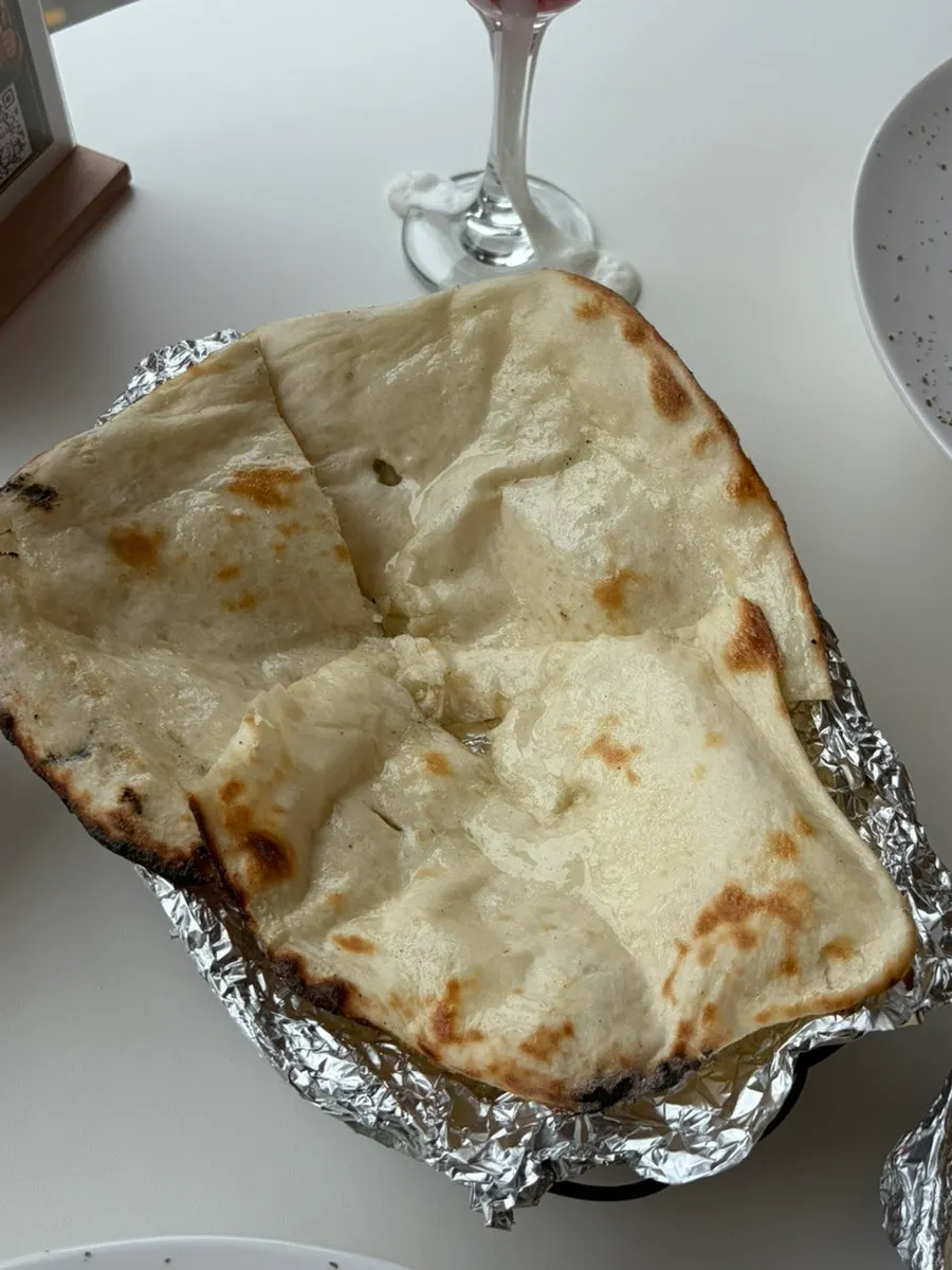 A large piece of butter garlic naan