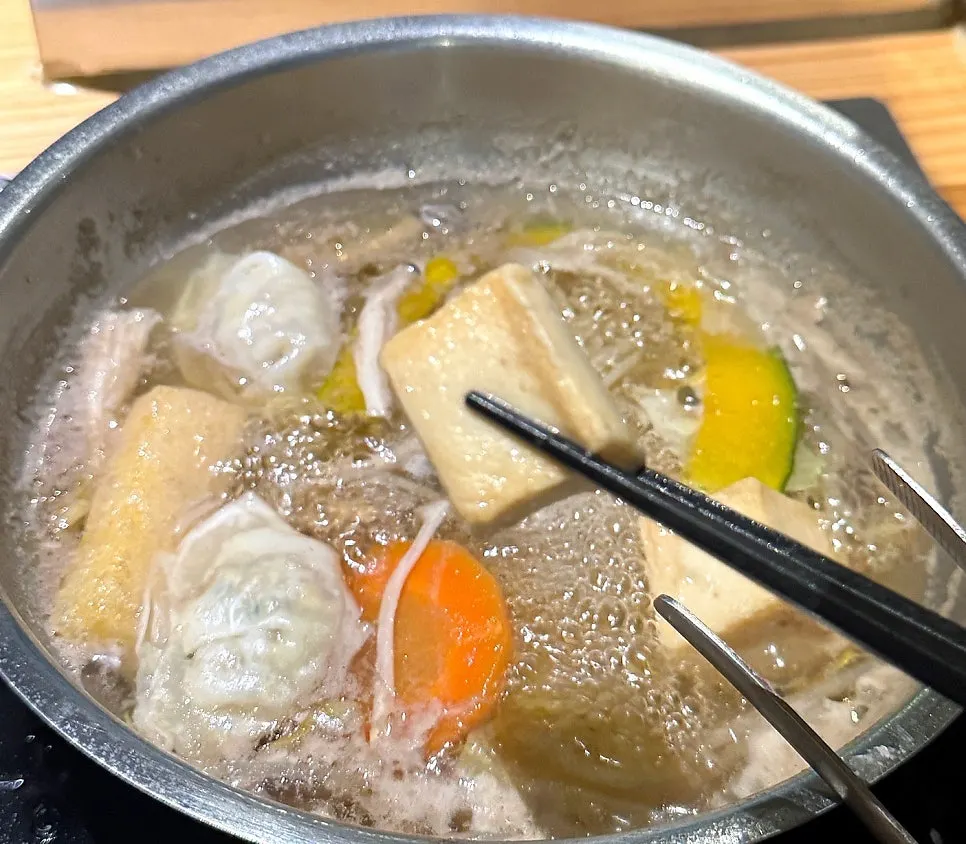 Dumplings and fish balls added to the clear broth