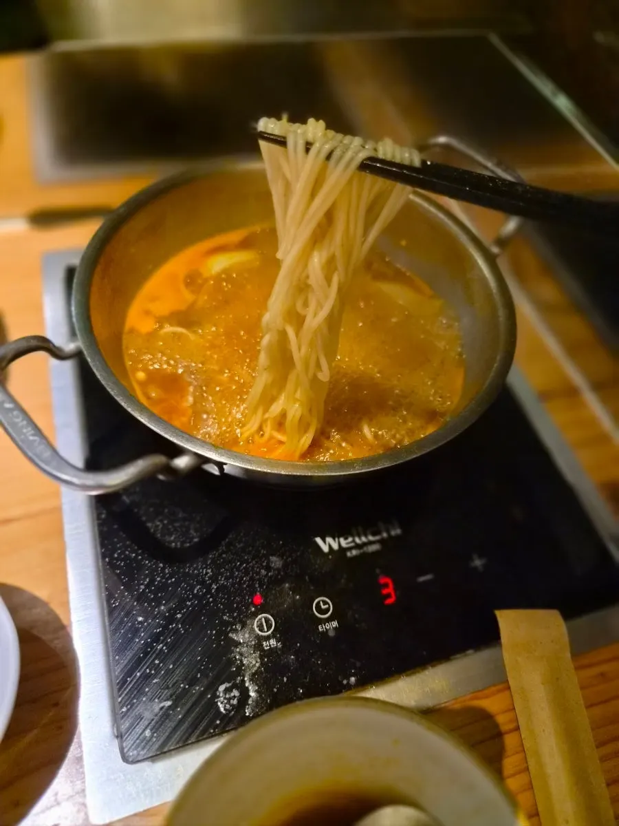 Kalguksu finished off in the spicy broth