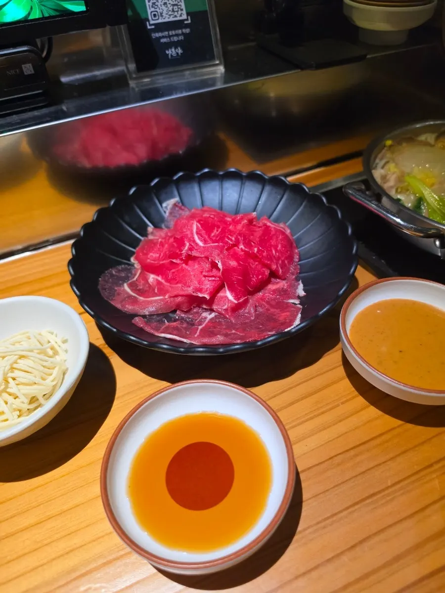 Individual pot boiling with a big pile of meat added