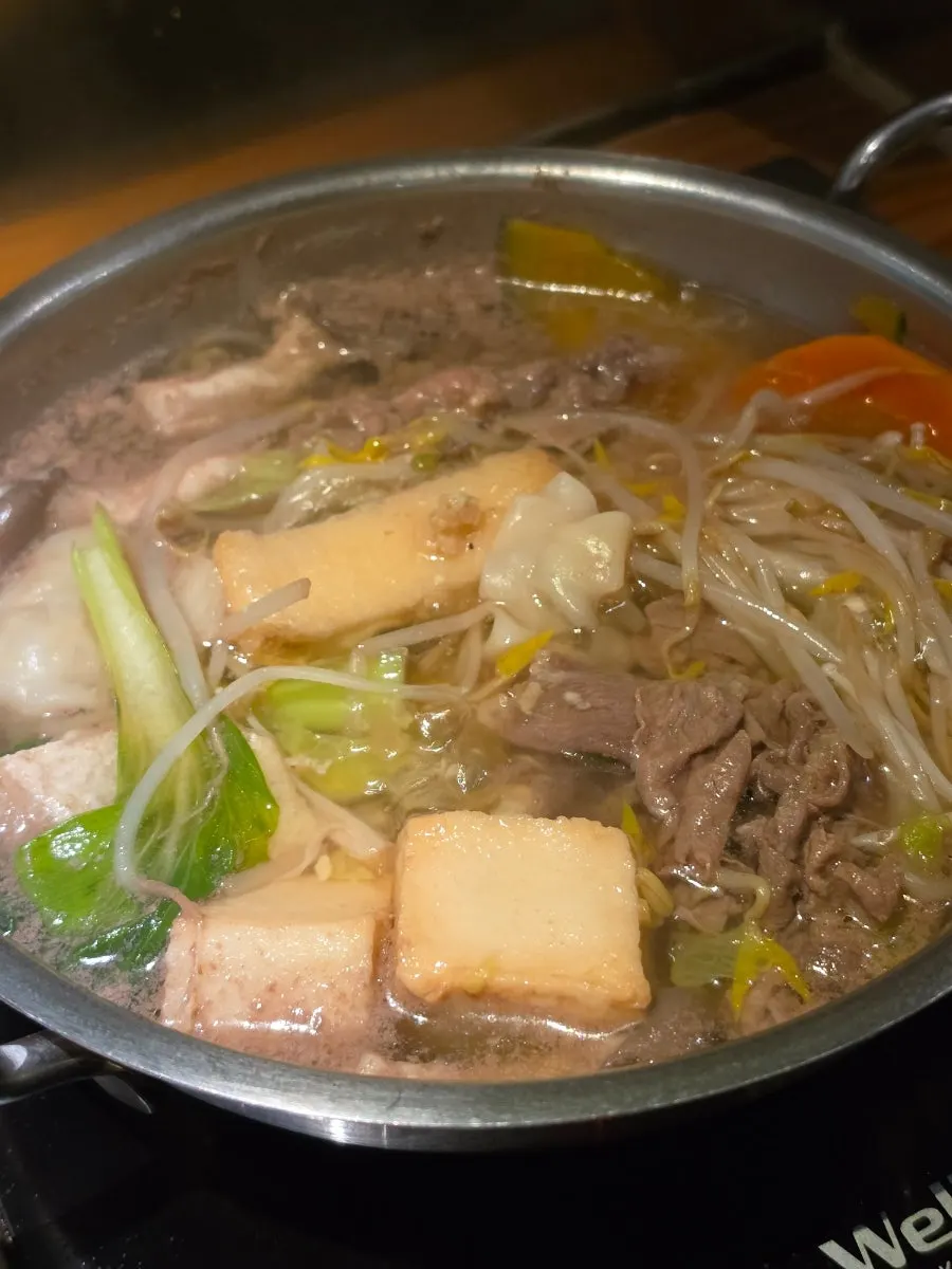 Clear broth shabu-shabu with meat and vegetables cooking