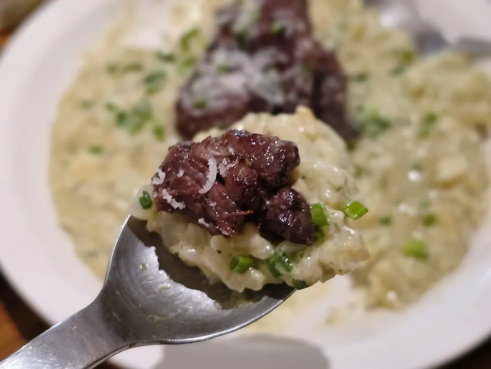 A spoonful of risotto eaten together with short rib