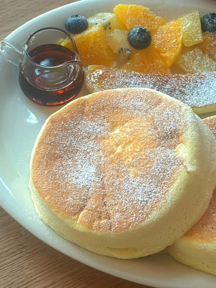 Maple syrup being poured onto the soufflé pancakes