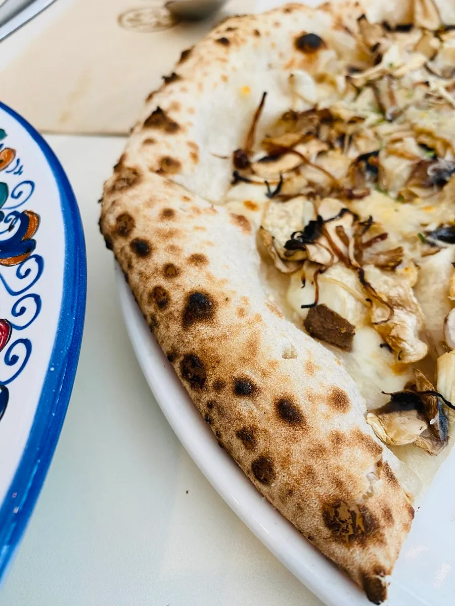 A slice of quattro funghi pizza