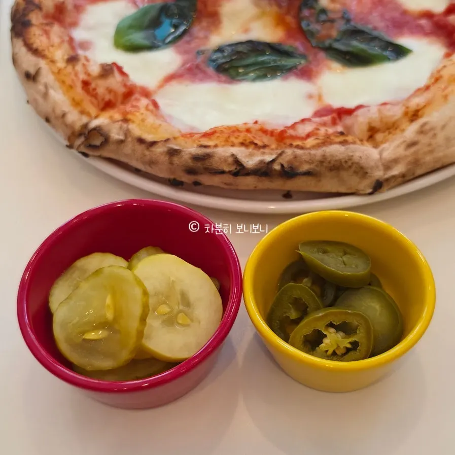 A chewy-dough pizza slice with pickles