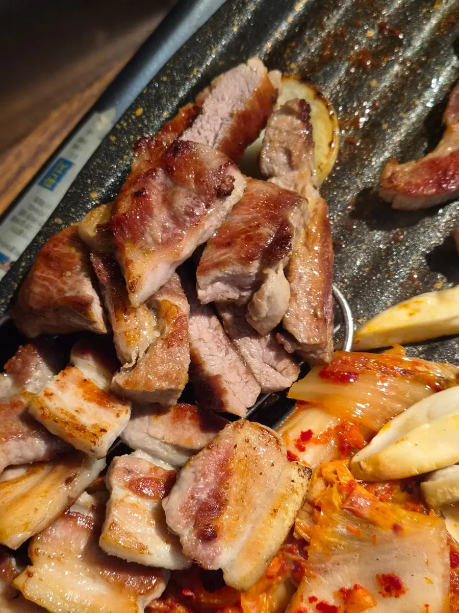 불판 하단에서 구워지는 김치와 야채