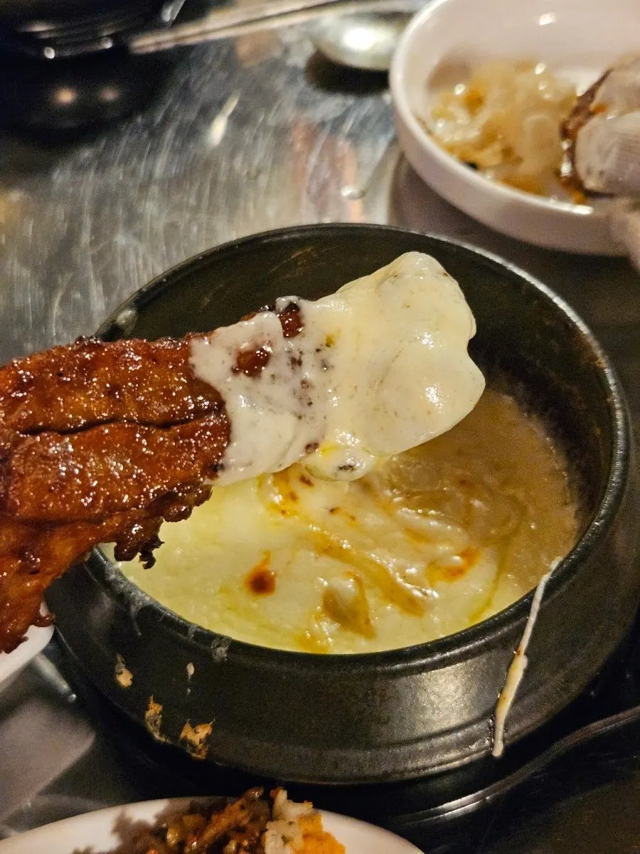 Spicy jjokgalbi dipped in the added cheese fondue