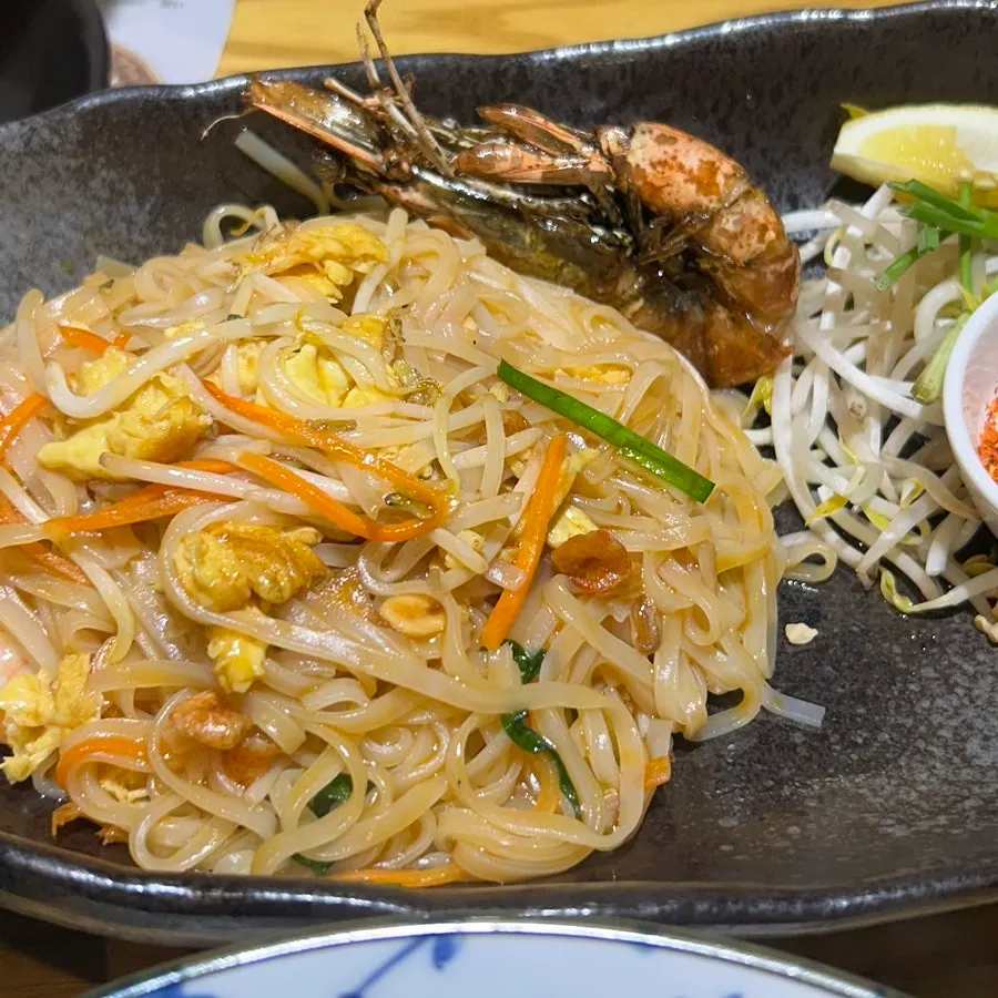 A bite of pad thai noodles twirled around the prawn