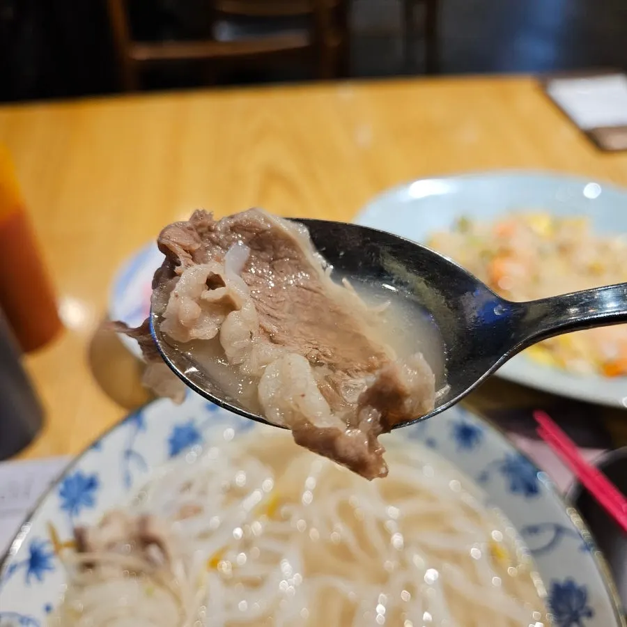 Lifting up a piece of pho meat