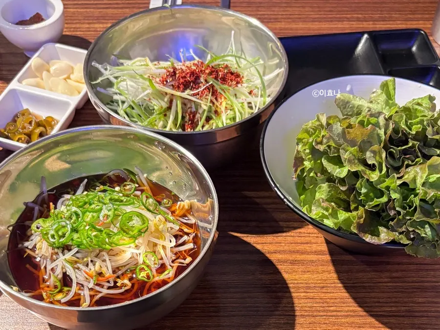 Table setting with bean sprout pickle, scallion salad and other side dishes