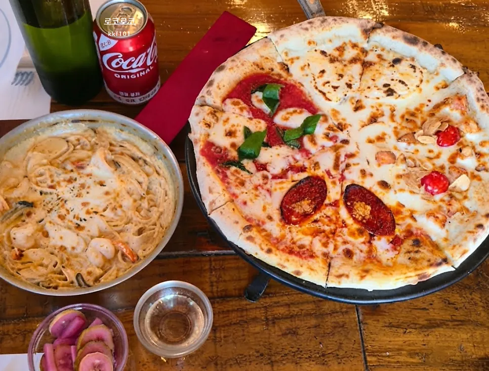 Table with Quattro Stagioni pizza and Gamberi Crema pasta together
