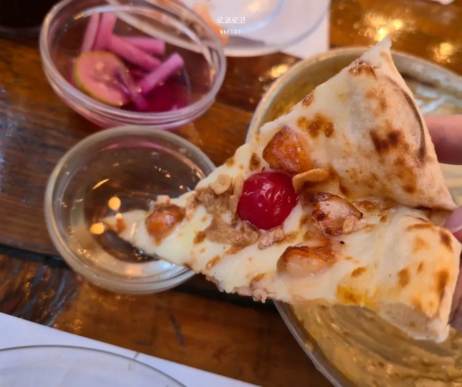 Lifting up a slice of Quattro Stagioni pizza
