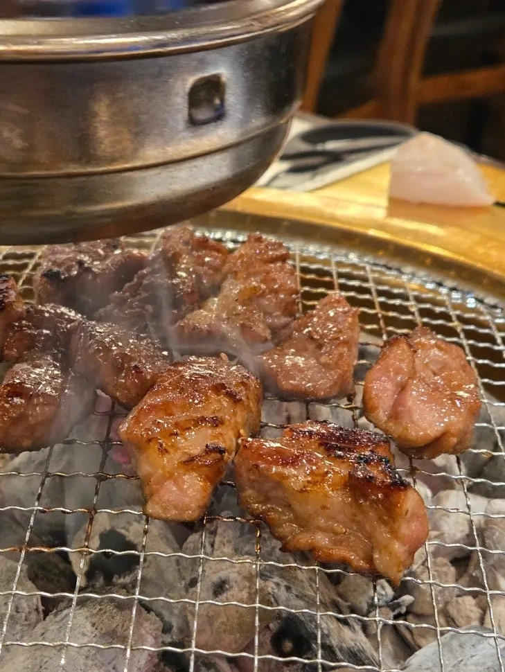 Seasoned pork galbi grilling over charcoal