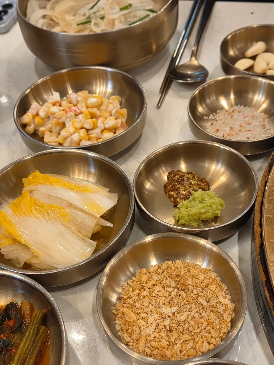 White kimchi, sliced onion and other side dishes at Geumseong Hoegwan