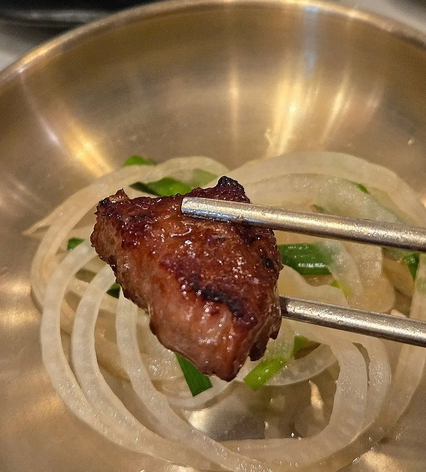 Seasoned pork galbi cooking over charcoal