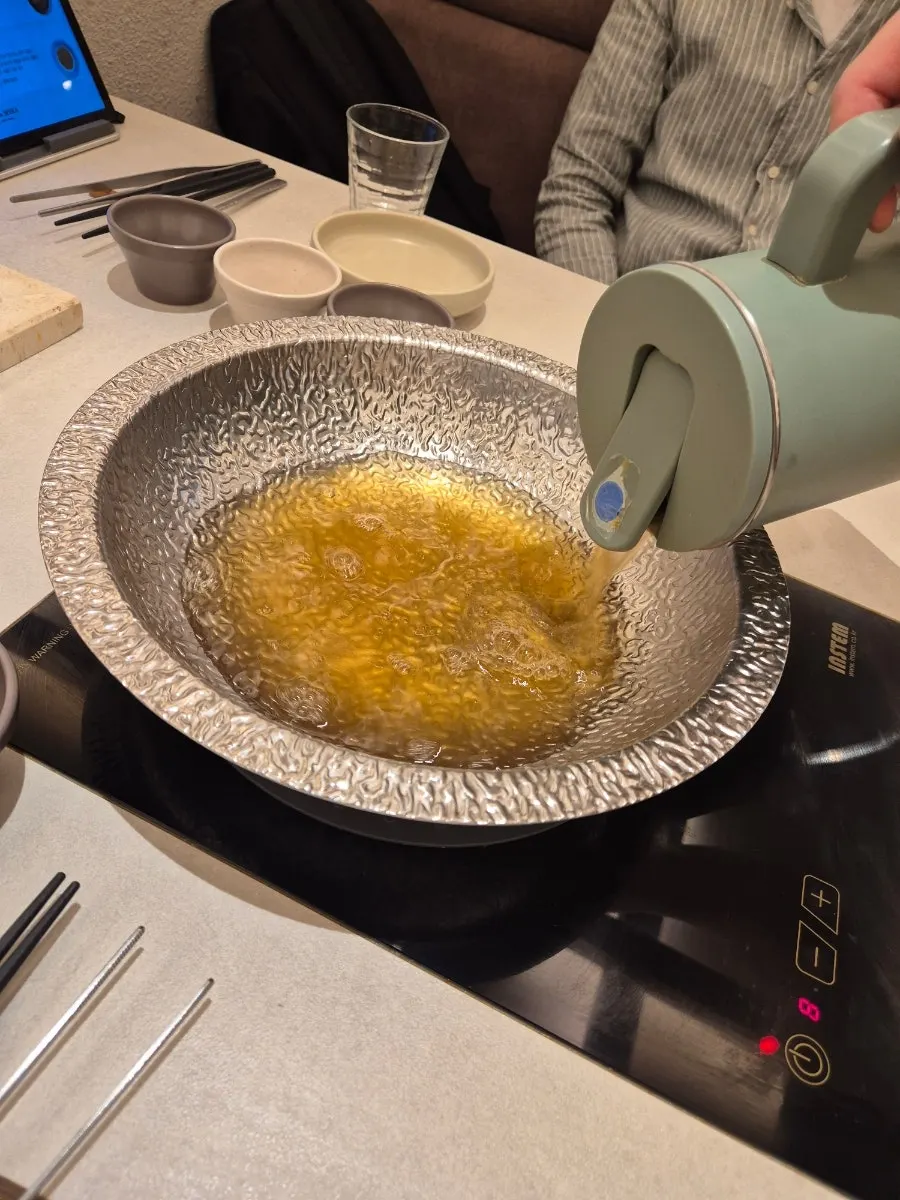 Shabu-shabu pot filled with clear mushroom broth