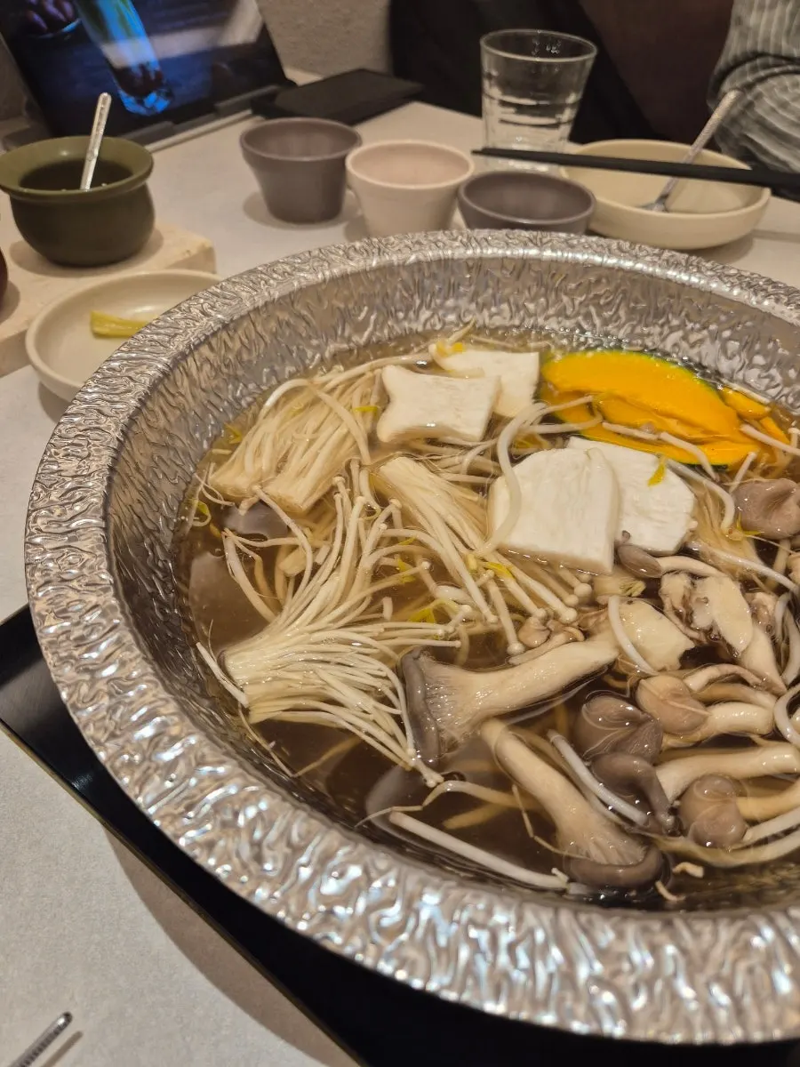 Broth boiling with mushrooms and sweet pumpkin