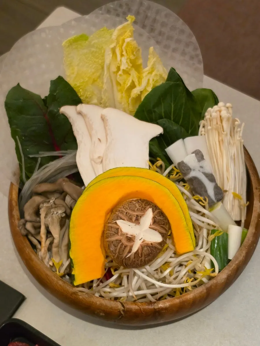 Table with mushroom broth pot placed on the burner