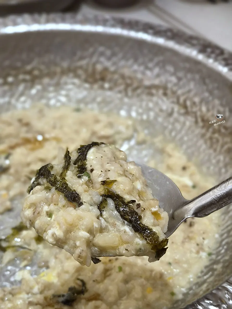 Mushroom broth porridge topped with seaweed flakes and sesame oil