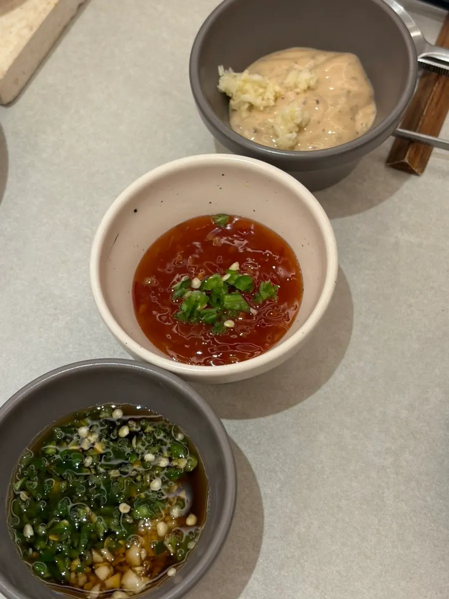 Small dishes of cheongyang chili peppers and minced garlic
