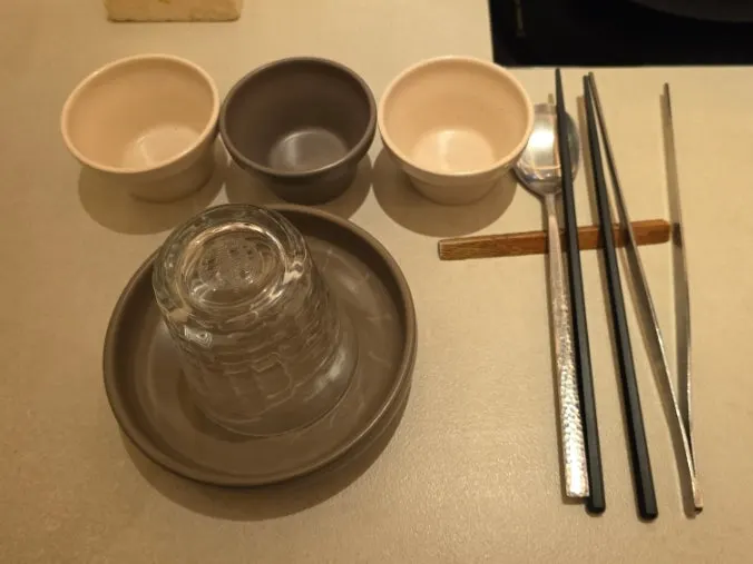 Table setting with sauce dishes, small plate and personal tongs