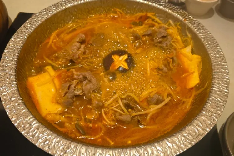 Spicy mushroom broth boiling with the ingredients added
