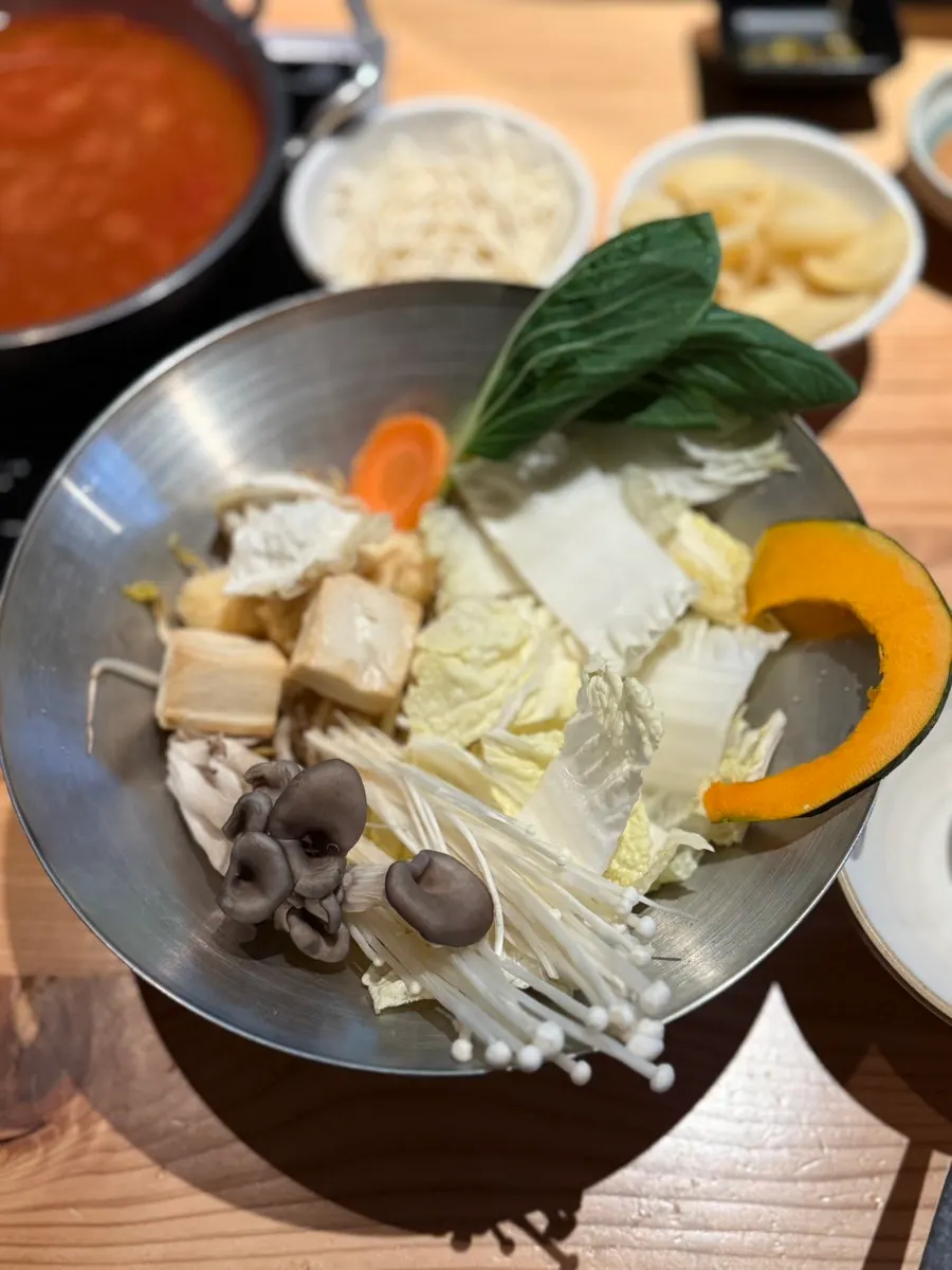 Adding vegetables to the boiling spicy broth