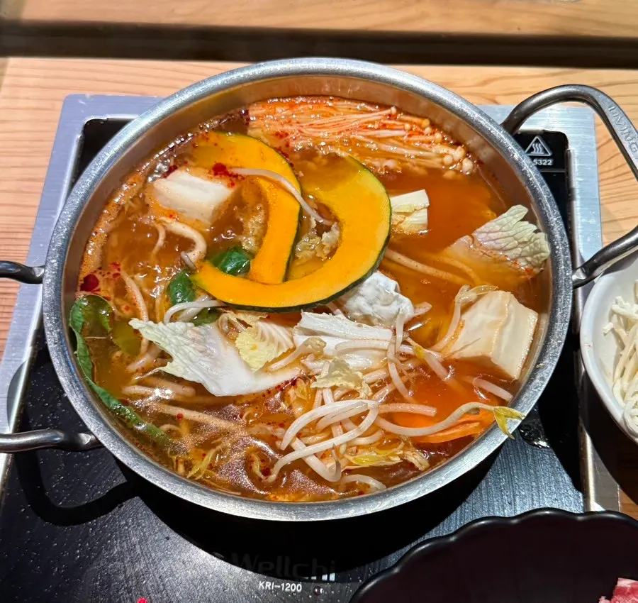 A bite of bok choy and bean sprouts wrapped in cooked meat