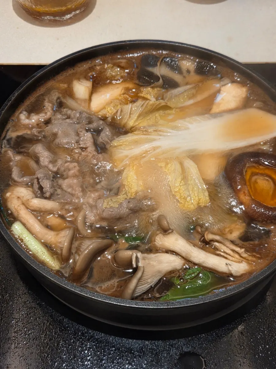 Sukiyaki spread with vegetables cooking in the pot