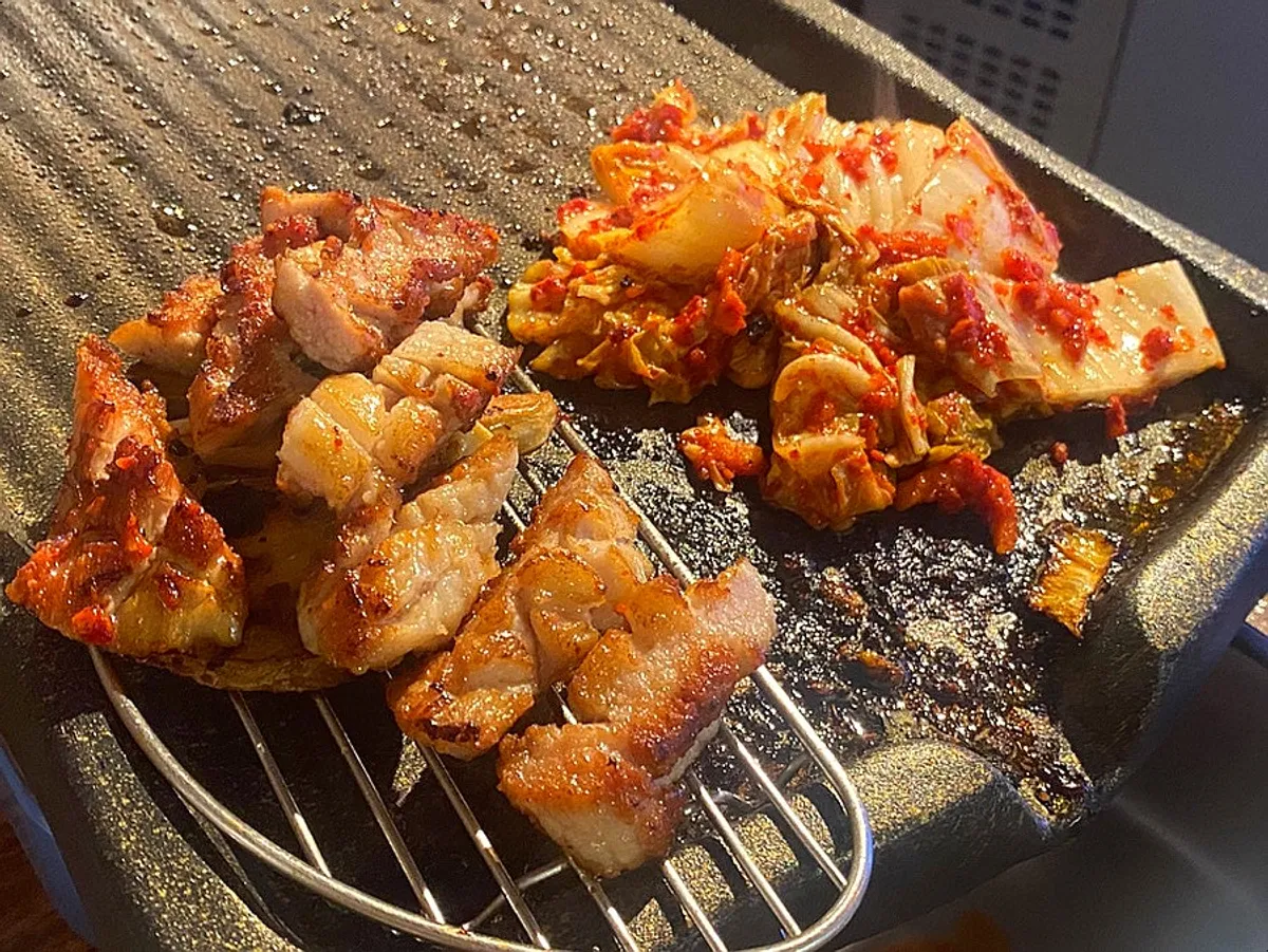 혼술 자리에 차려진 고기와 술 한 잔