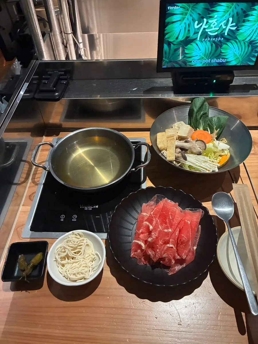 Vertical shot of the solo clear broth shabu-shabu pot at Nahonsha