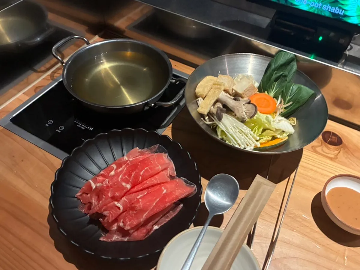 Solo shabu pot simmering with ingredients added in order